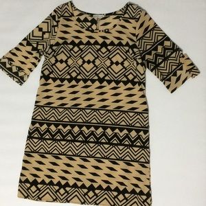 Tan and black dress with cuffed sleeves.